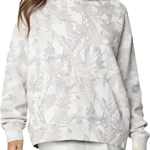 Front view of a woman wearing an oversized half-zip camouflage hoodie