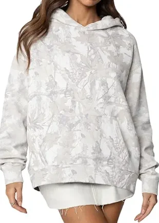 Front view of a woman wearing an oversized half-zip camouflage hoodie